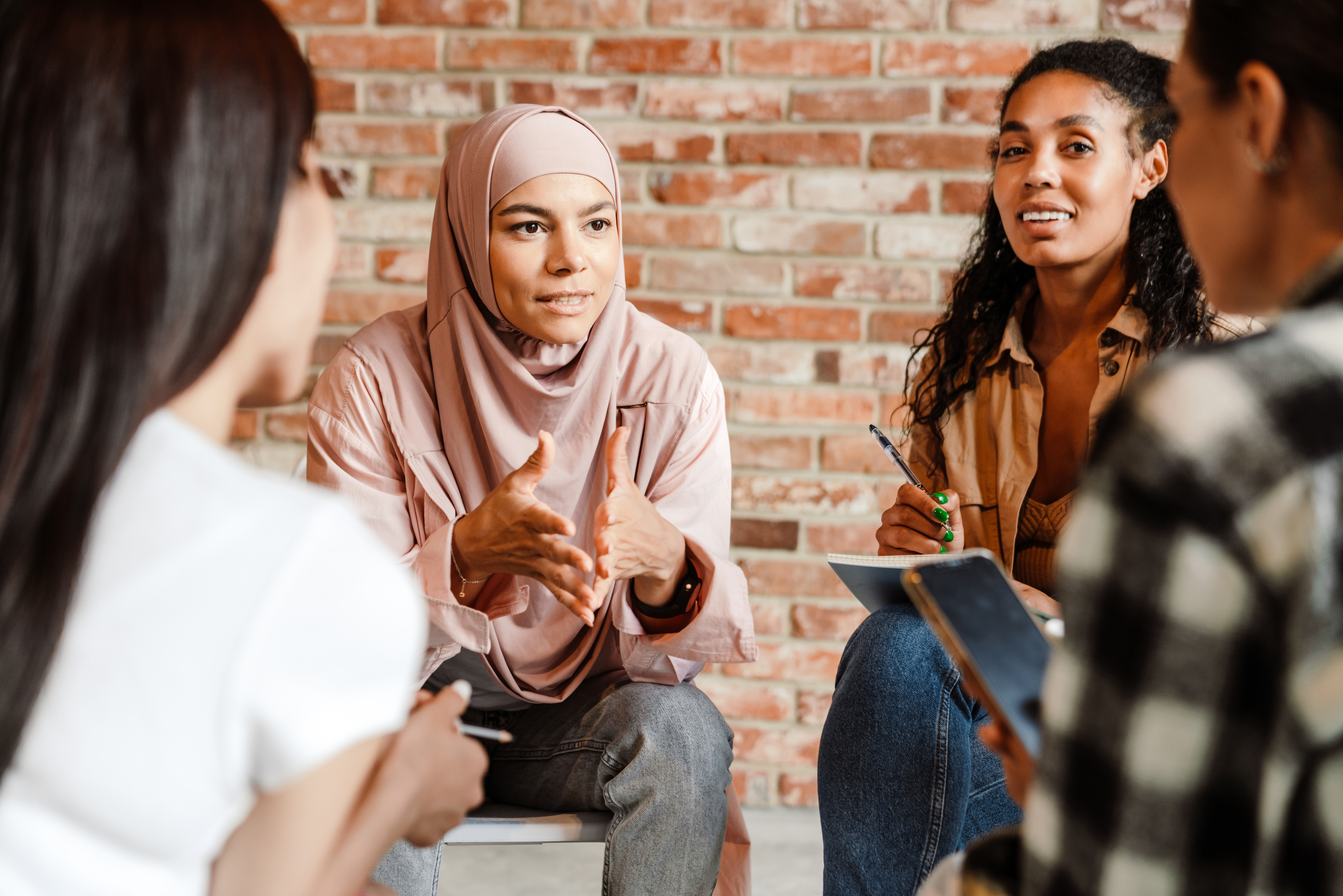 Diversity Multiracial young women discussing project during meeting indoors