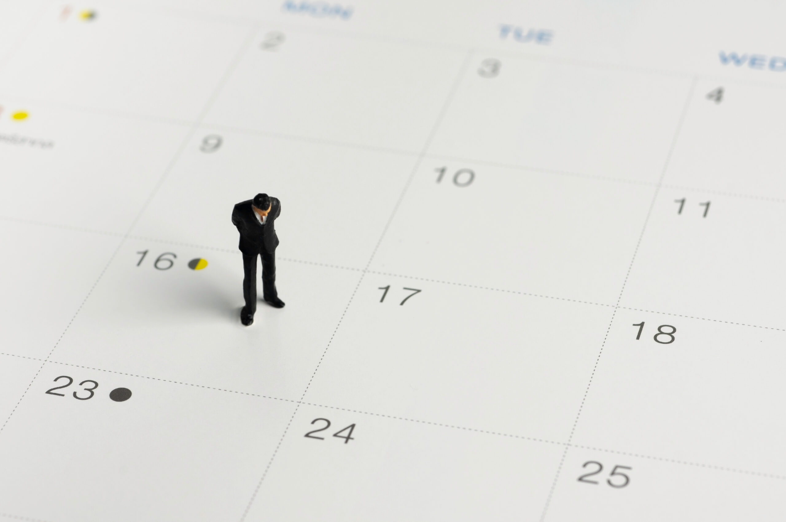 Selective focus miniature businessman standing on calendar check