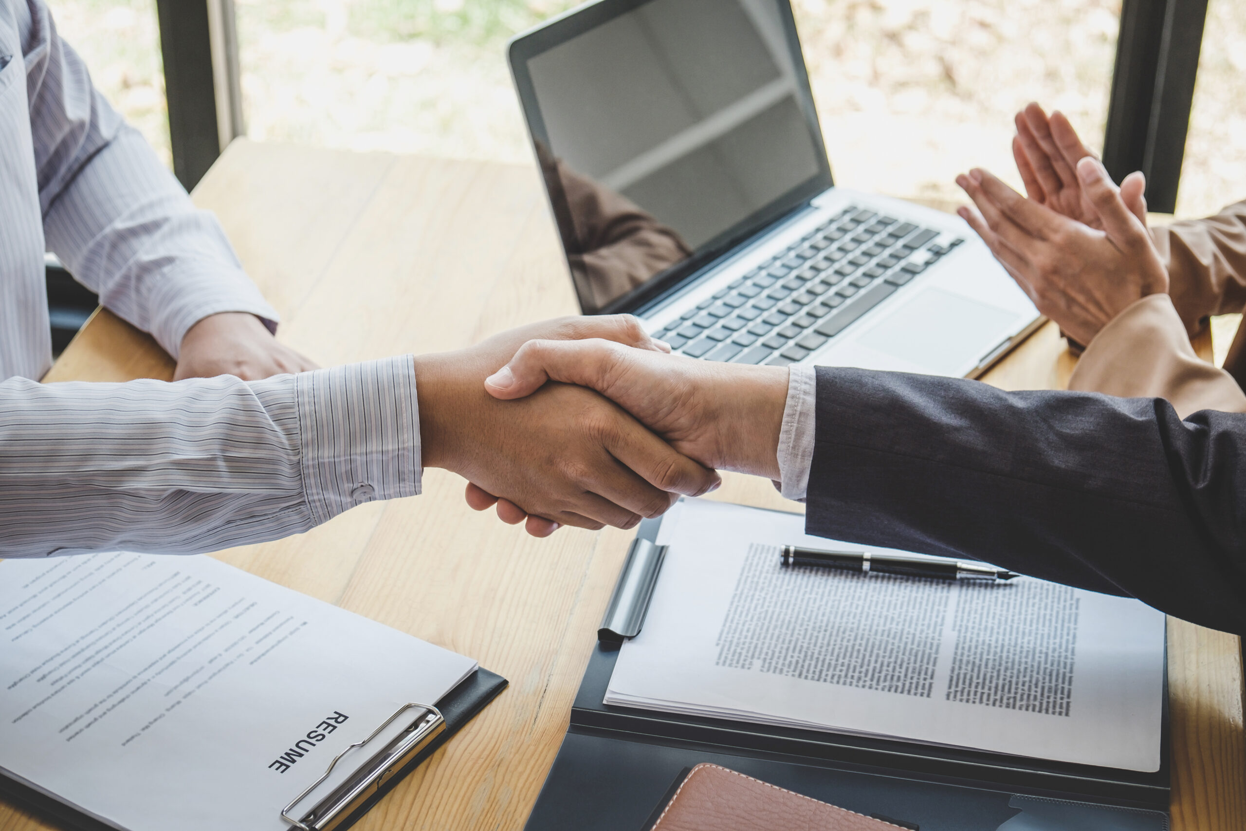 Greeting new colleagues, Handshake while job interviewing, male candidate shaking hands with Interviewer or employer after a job interview, employment and recruitment concept.