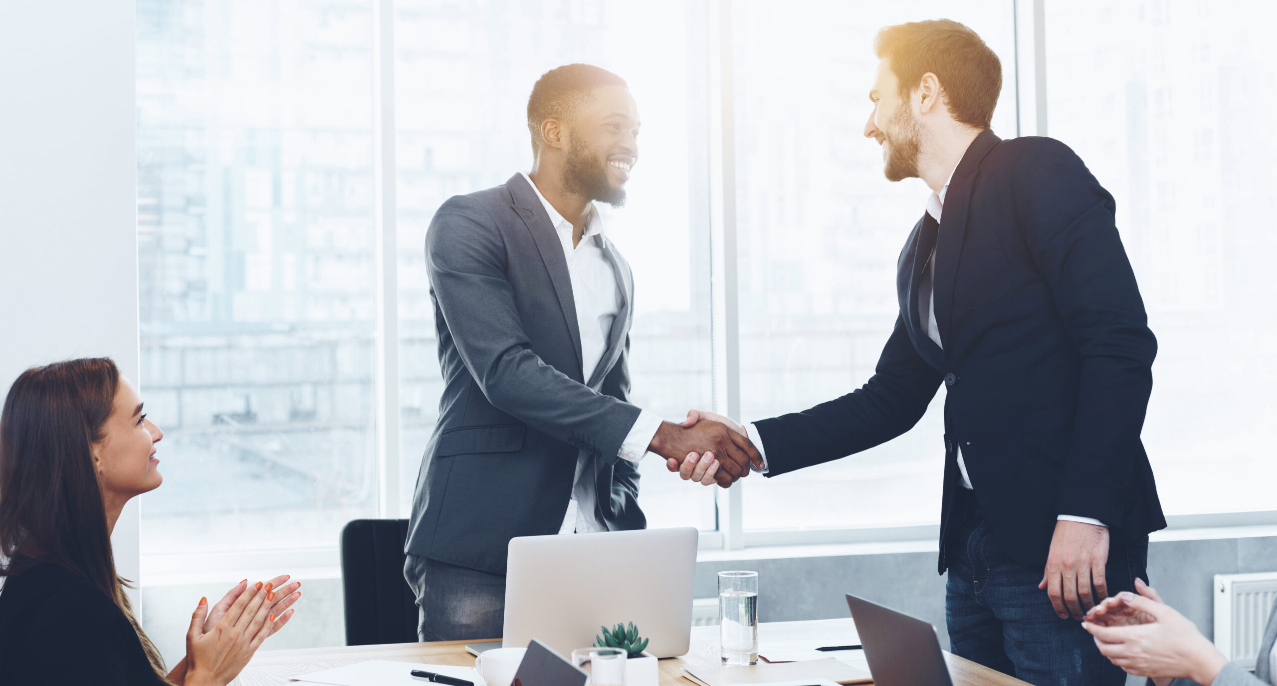 Boss welcoming new employee and shaking hand Boss welcoming new employee and shaking hands at meeting in office