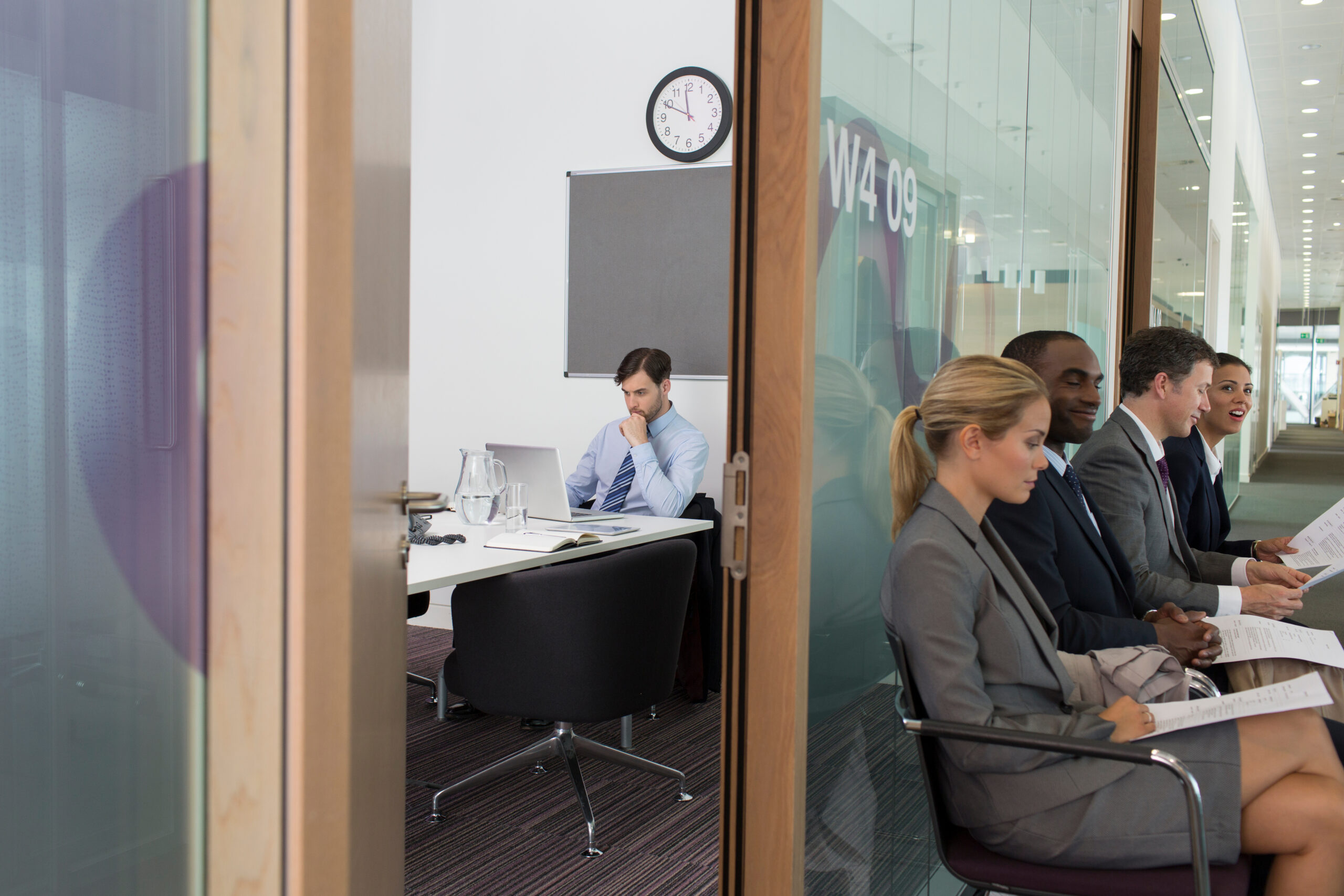 Business people waiting for job interview in office corridor