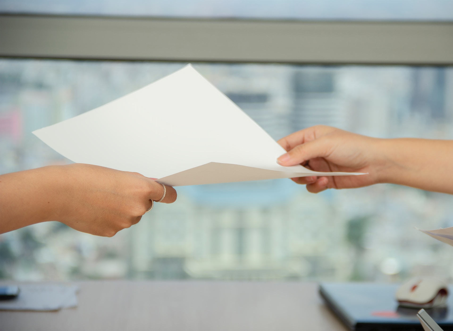 A manager passing a piece of paper to a job candidate