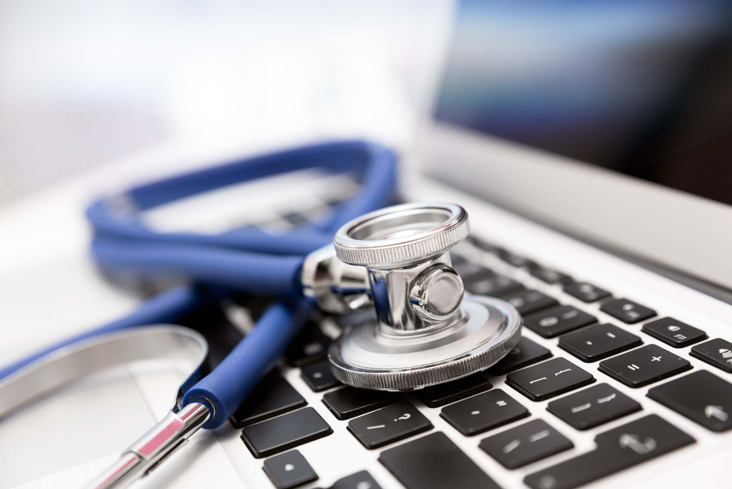 Stethoscope on laptop keyboard. Health care or IT security concept