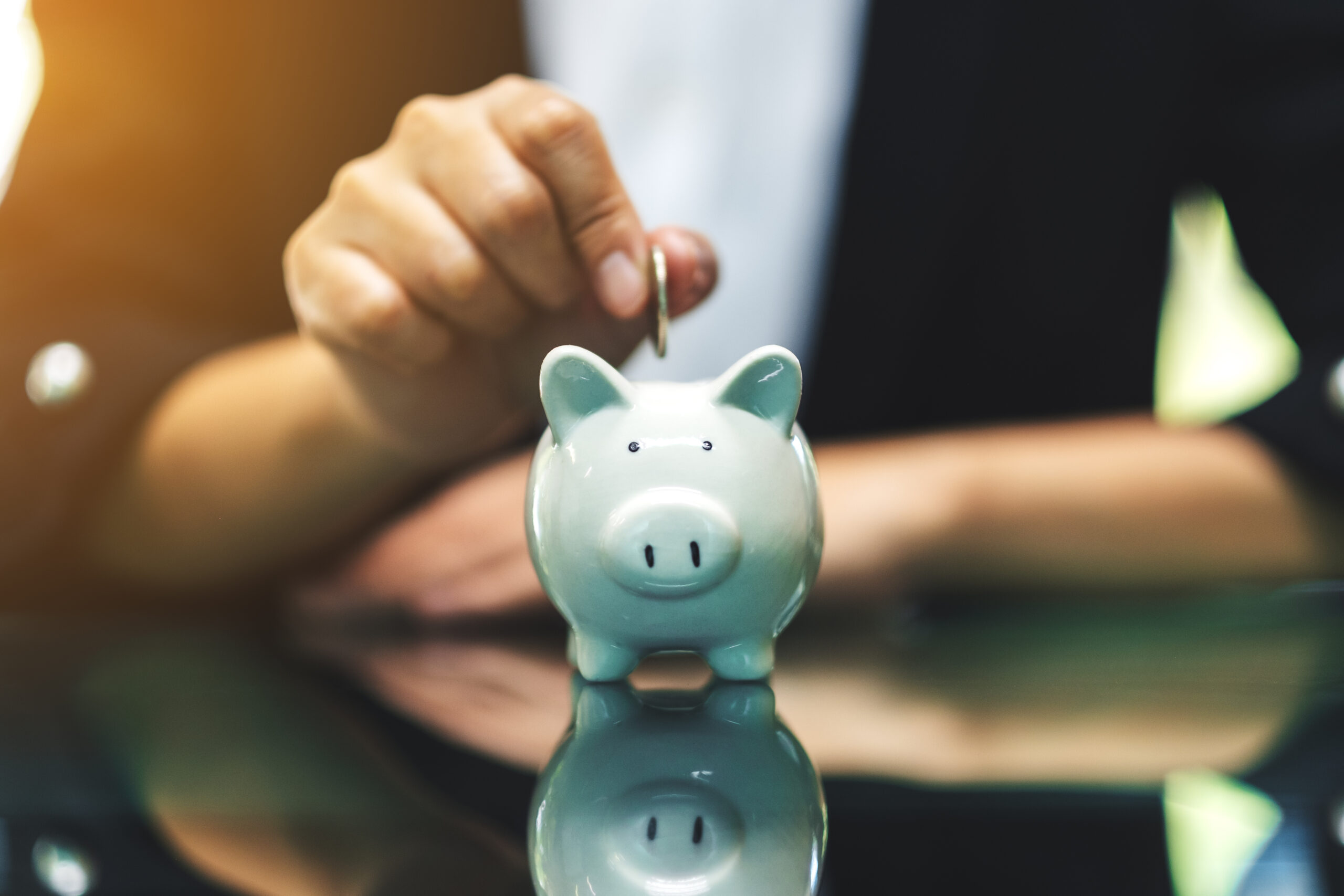 A woman putting coins into piggy bank for saving money concept a piggy bank