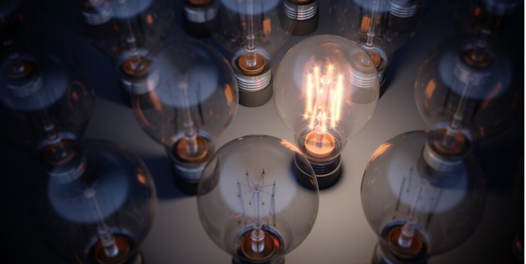 A glowing light bulb standing out from the crowd.
