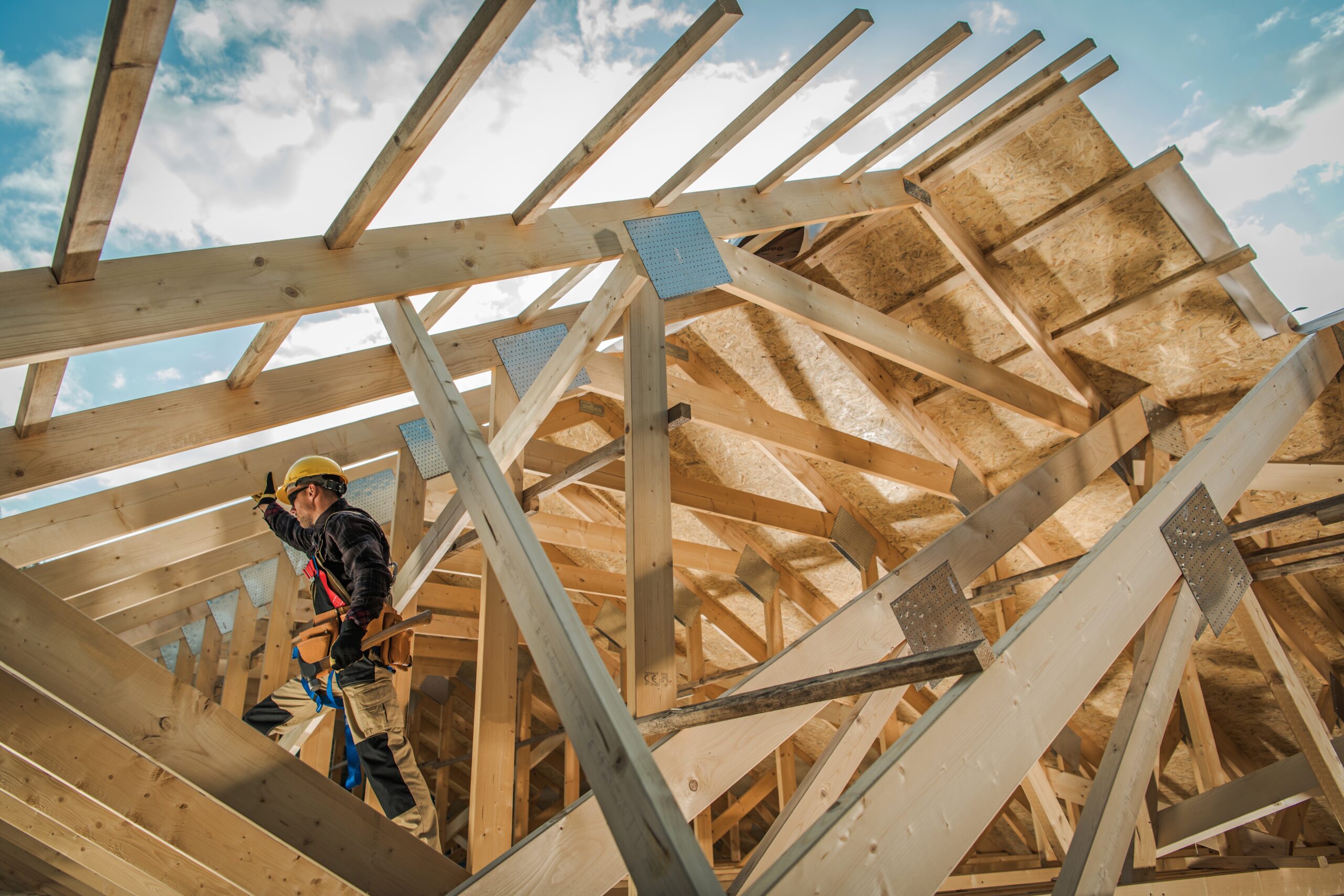 A man working on framing a home.