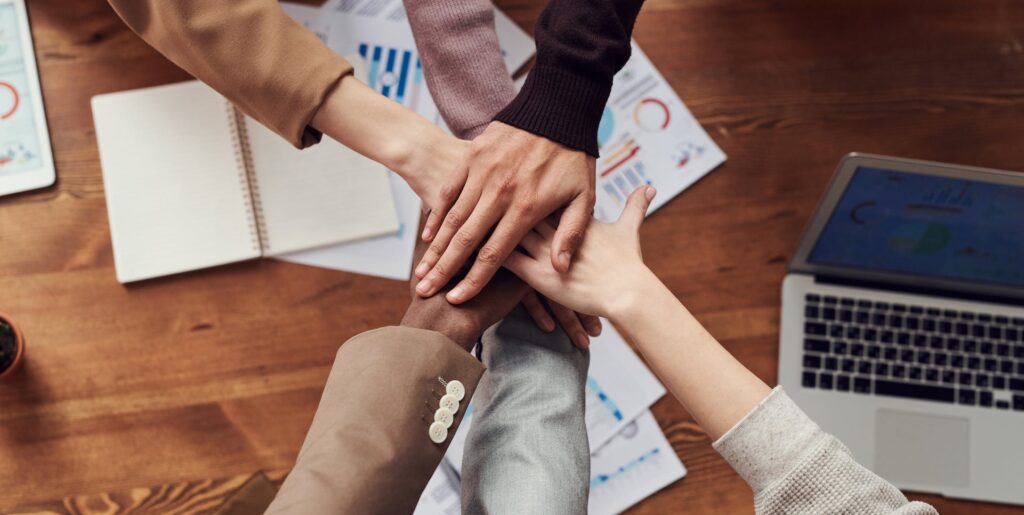 a diverse group of people putting their hands together