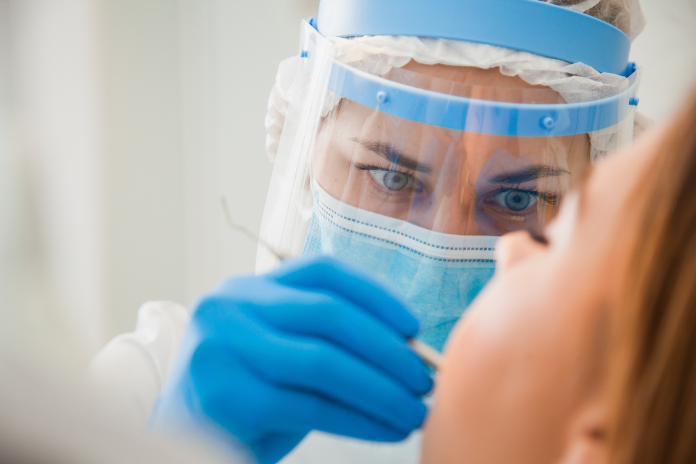 A dentist inspecting a patient's teeth.