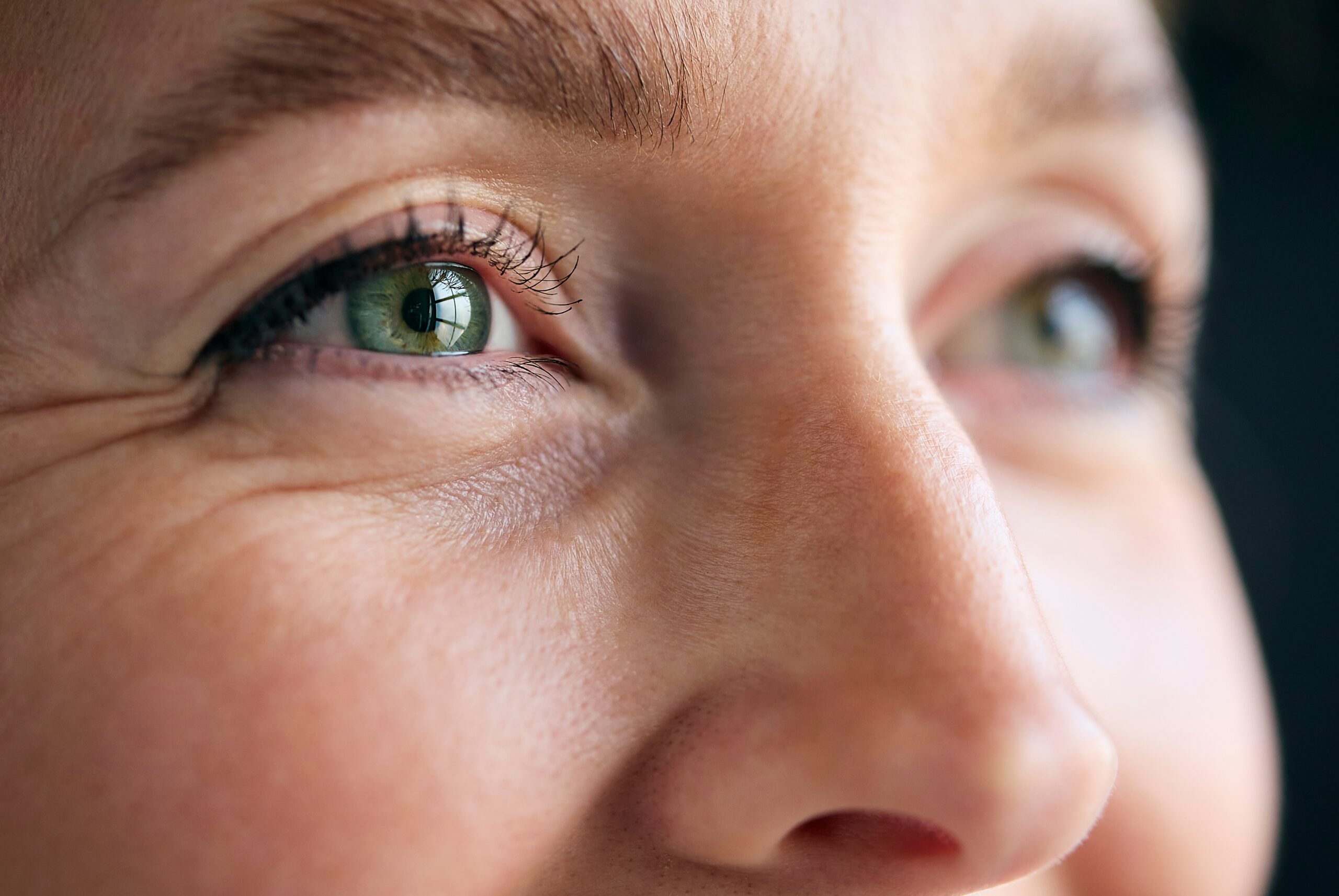 Macro Studio Expression Shot Of Woman's Smiling Eyes With Close Up On Eyelashes And Pupil